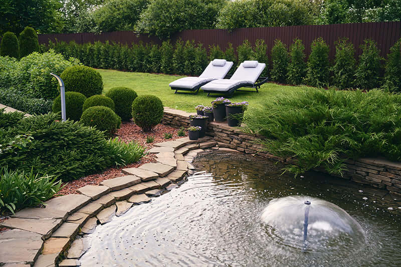 Stone-edged pond with central fountain and ripples in water feature