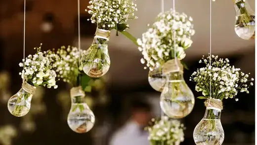 Clear glass light bulb vases with delicate white babys breath flowers