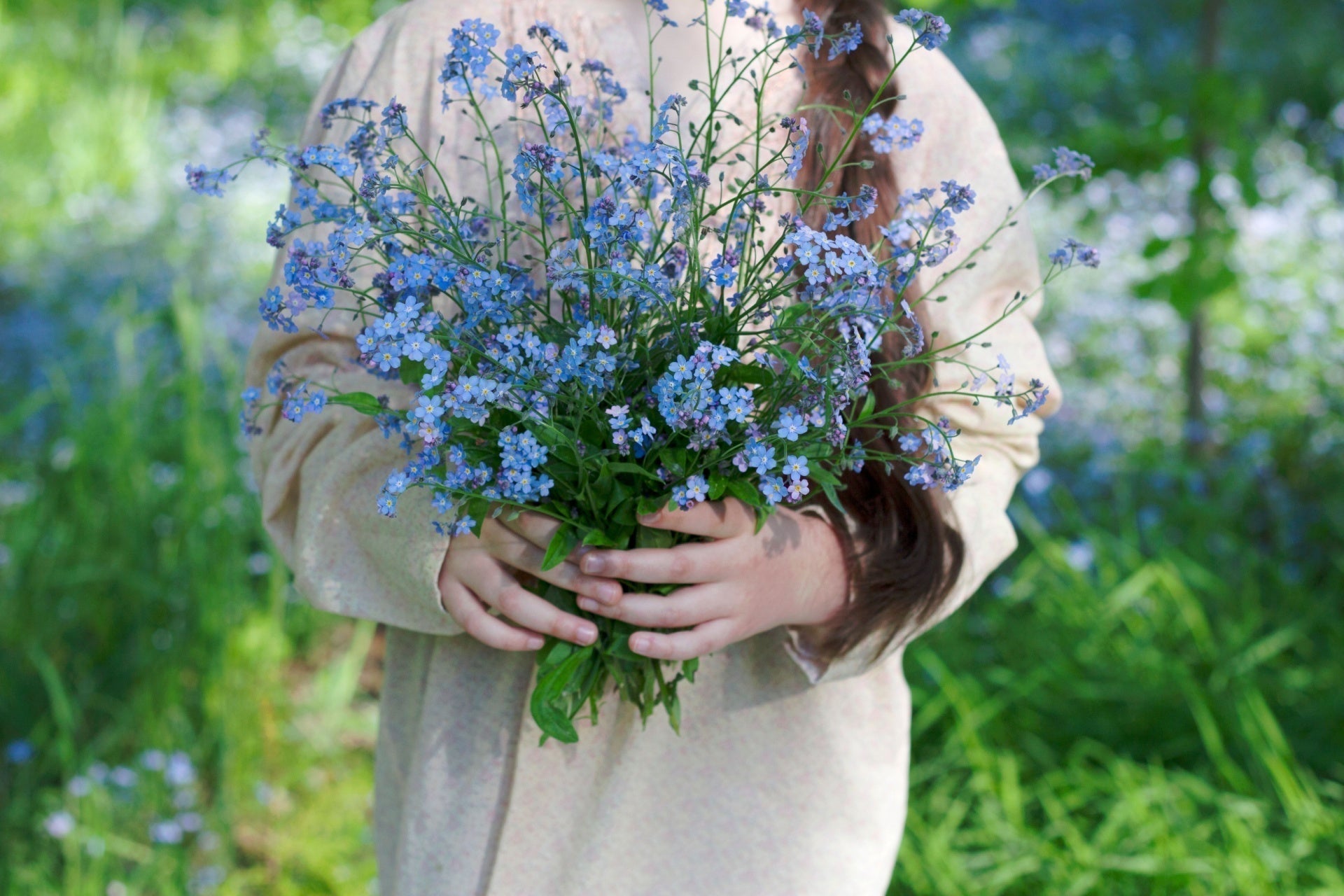 Vibrant blue forget-me-nots bouquet in hands, garden sweethearts