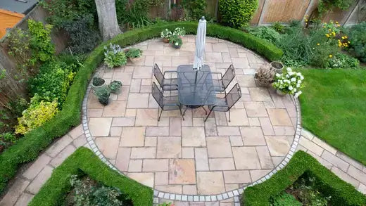 Black metal patio table and chairs in circular stone courtyard