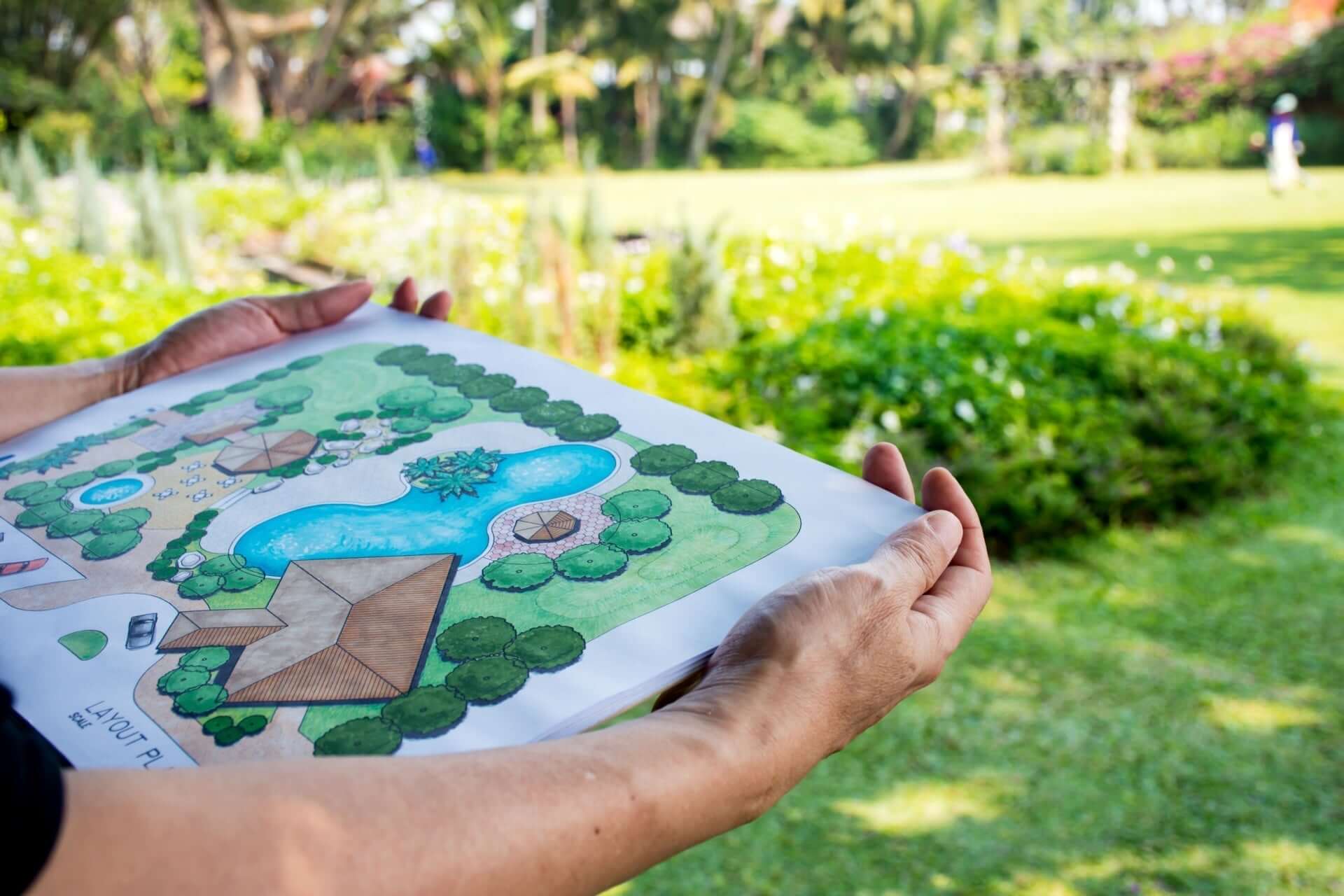 Hand-drawn sustainable garden layout with blue pond and green shrubs