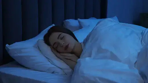 Woman sleeping peacefully under white duvet to soothe sleep