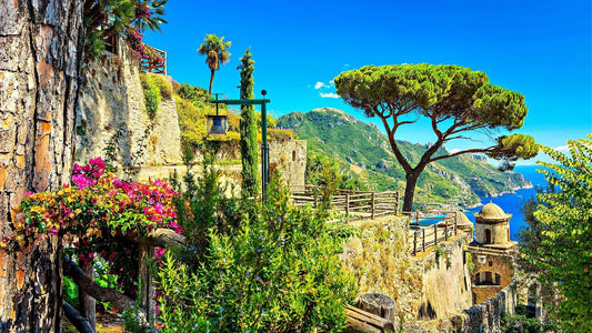Stone pathway winds through lush greenery, pink flowers in crafted landscape