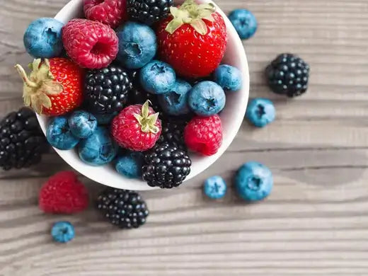 Colorful fresh berries in white bowl for daily health boost