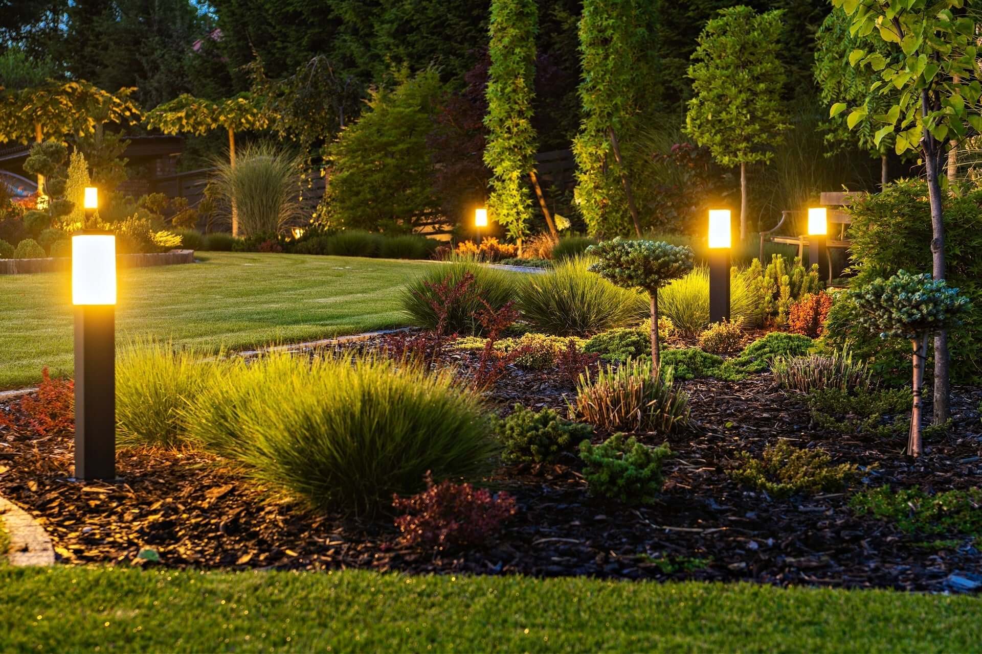 Warm-toned solar pathway lights illuminating garden at dusk