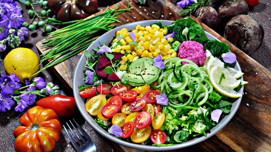 Vibrant edible landscaping salad with corn, avocado, zucchini, tomatoes, beets, flowers
