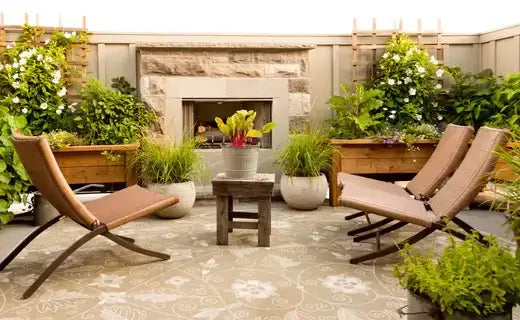 Beige leather lounge chairs with metal frames on patterned rug in outdoor patio oasis