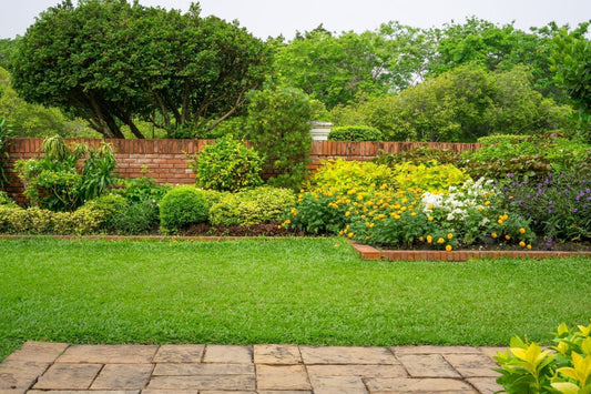Lush green lawn with brick pathway and vibrant flowerbeds for garden beauty