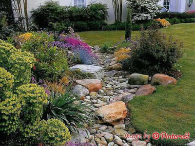 Natural stone garden stream with smooth brown and gray rocks from TN Nursery