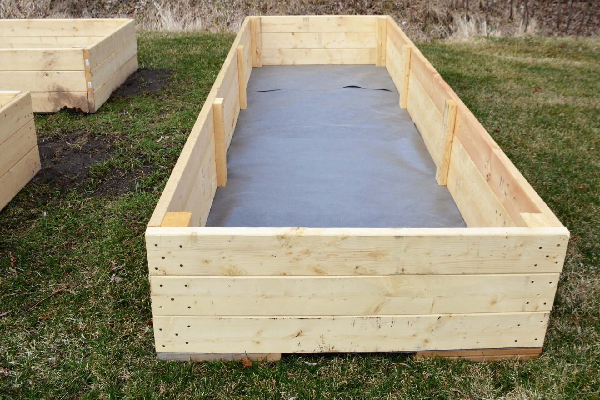 Light wooden raised garden bed with gray liner for productive layout
