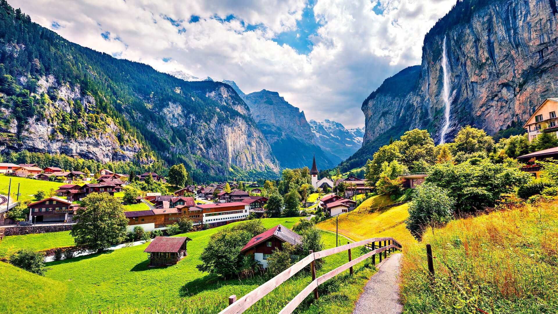 Picturesque village in lush valley with cedar trees and farmhouse roofs